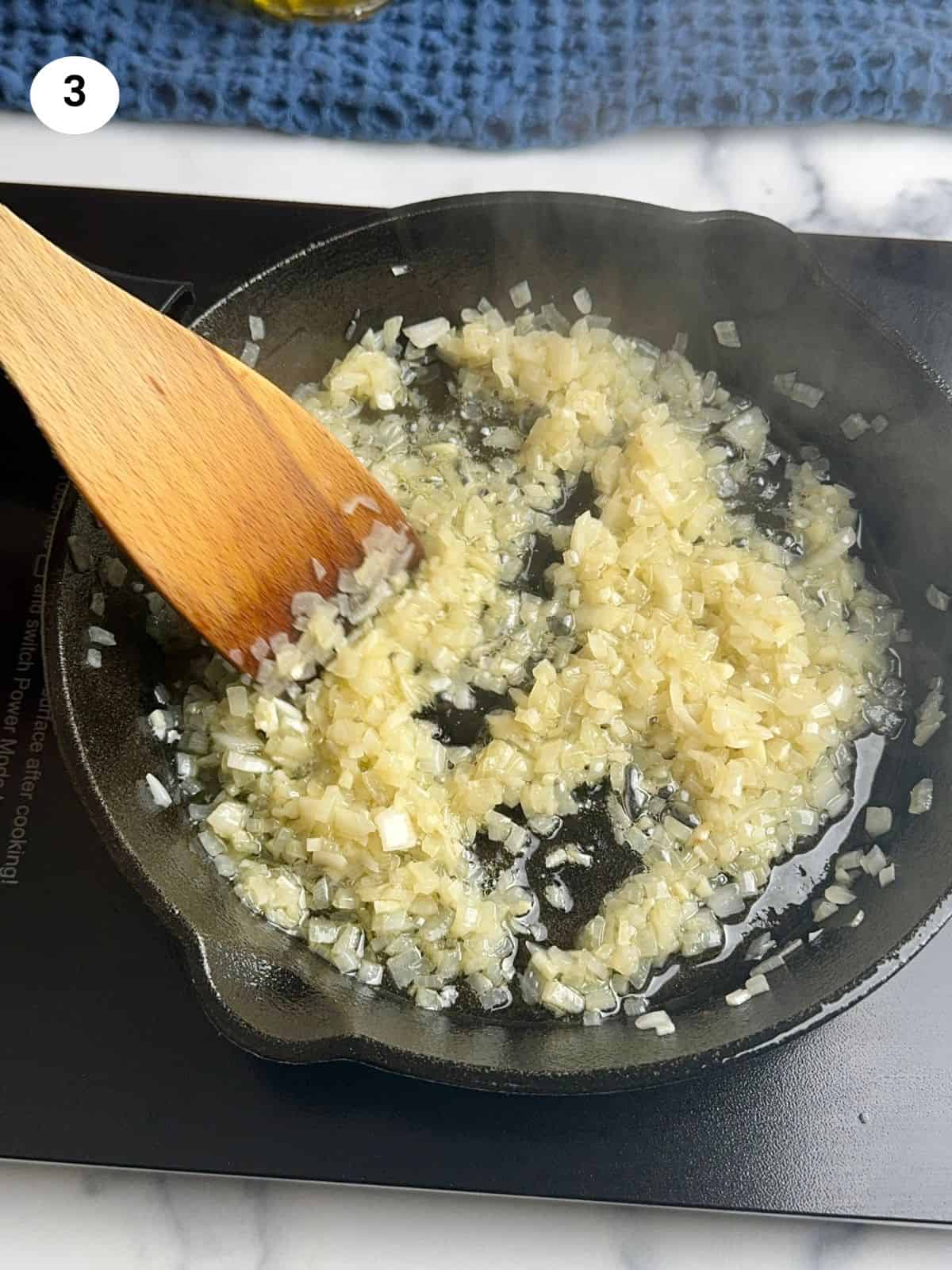 Cooking the chopped onion in the cast iron pan.