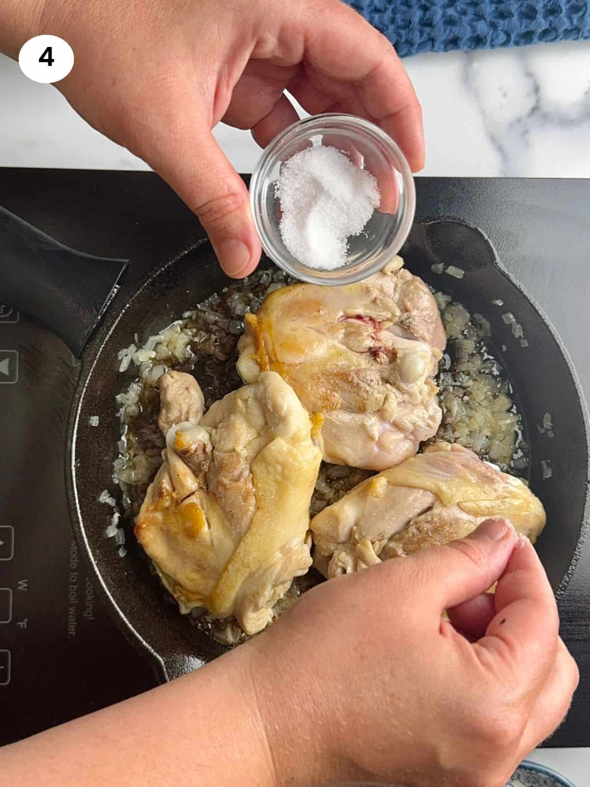 Seasoning the chicken with salt.