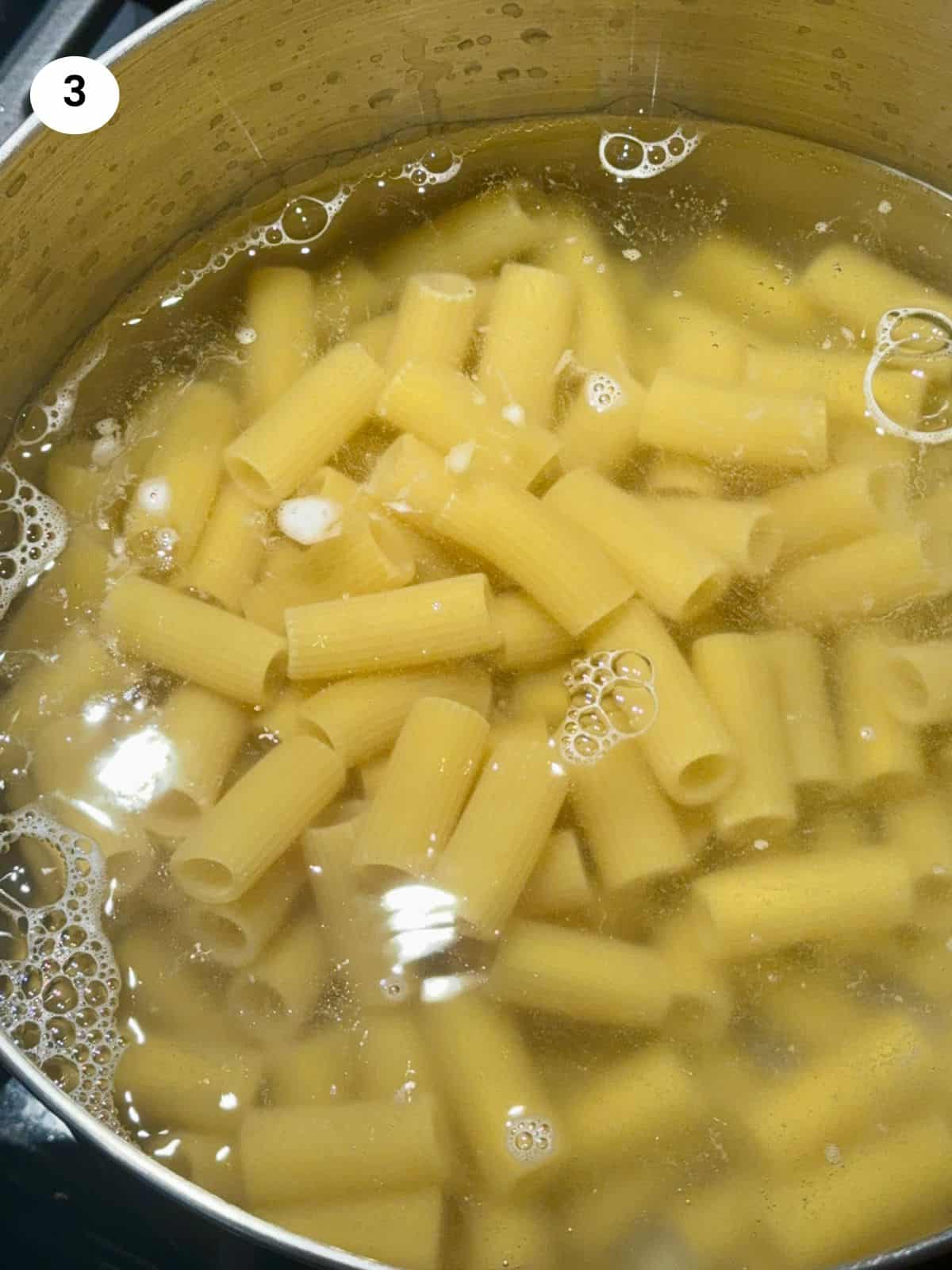 Adding the pasta to the boiling water.