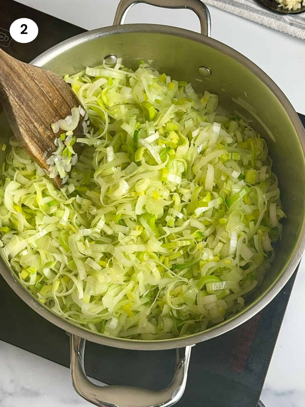 Cooking the leek and onions in a pot.