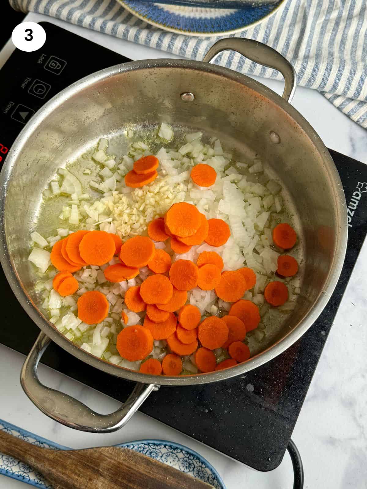 Sauteing the onion, garlic and carrot slices.