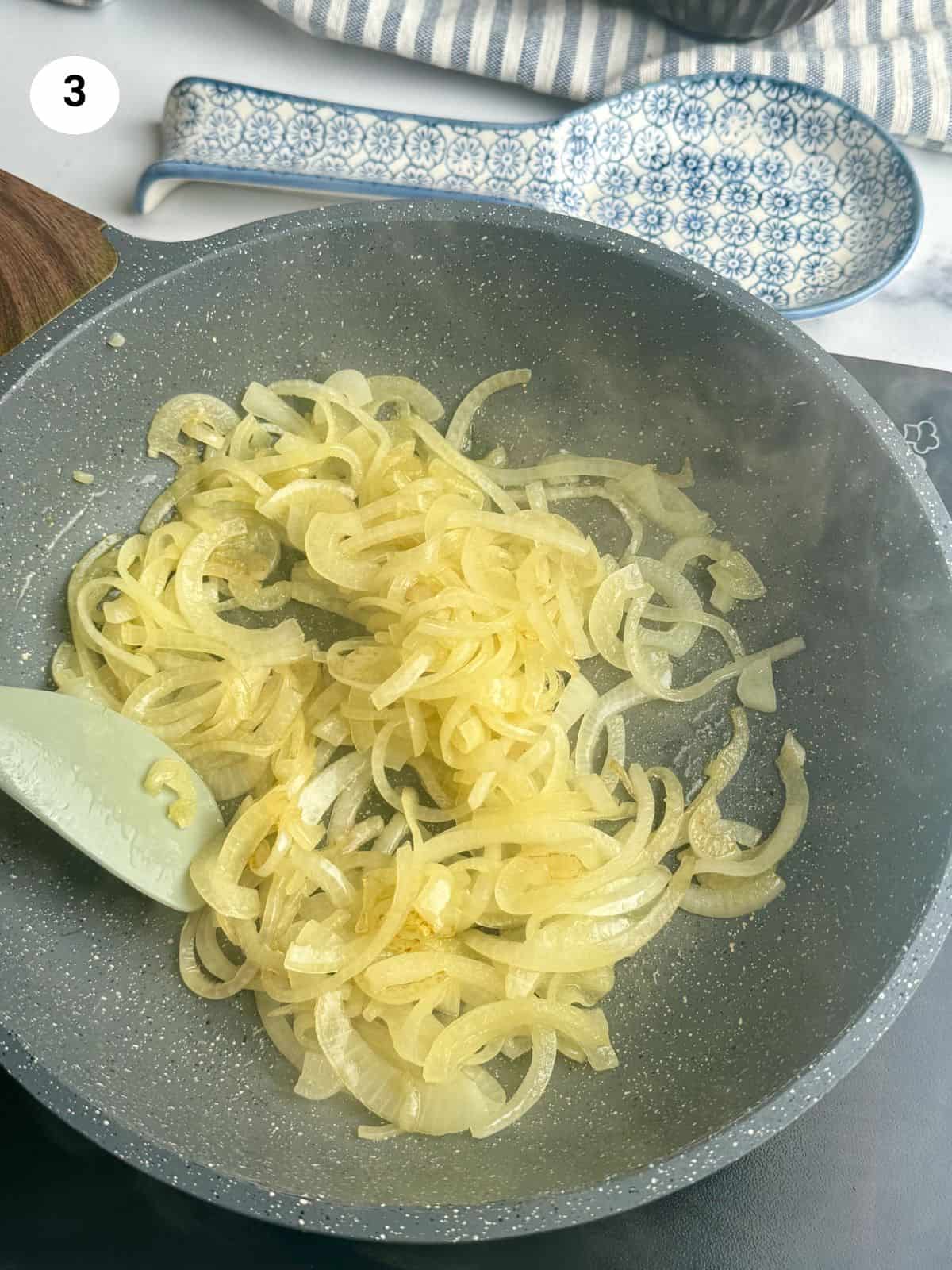 Cooked onion slices in the frying pan.