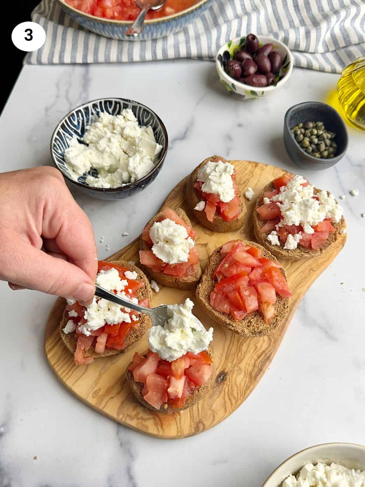 Placing cheese with a spoon on a rusk.