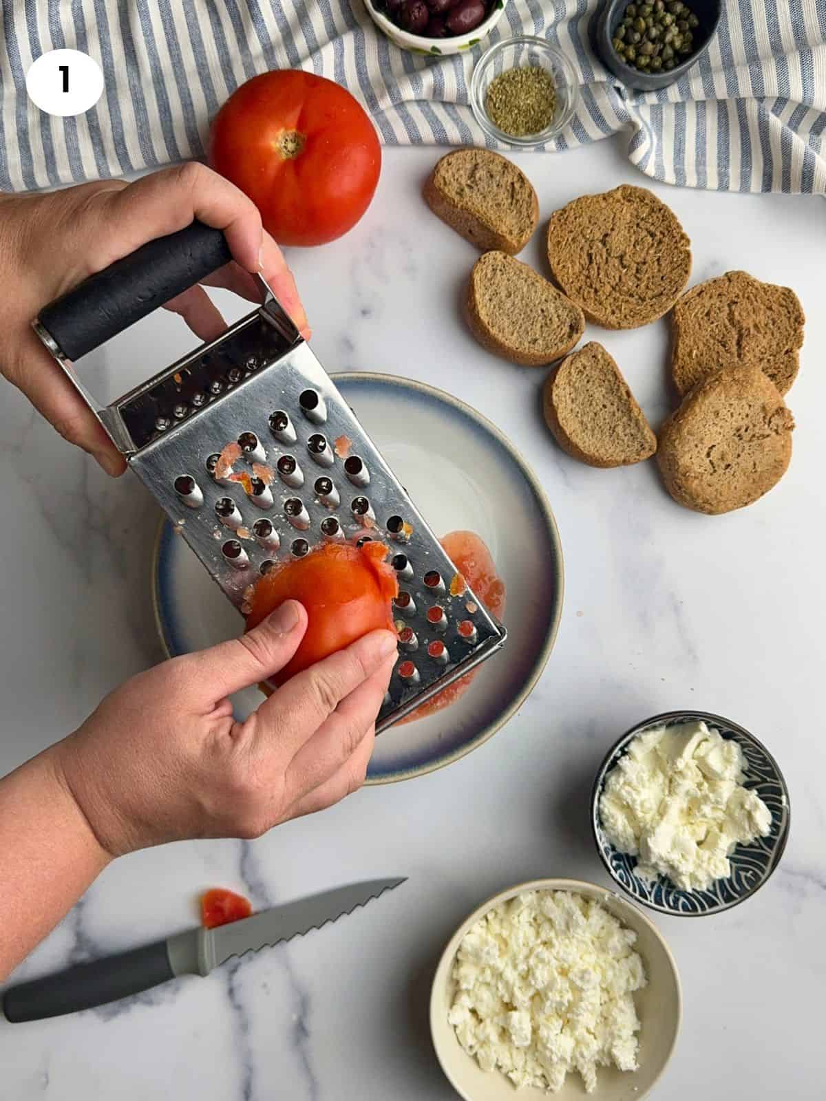 Grating a tomato in a bowl.