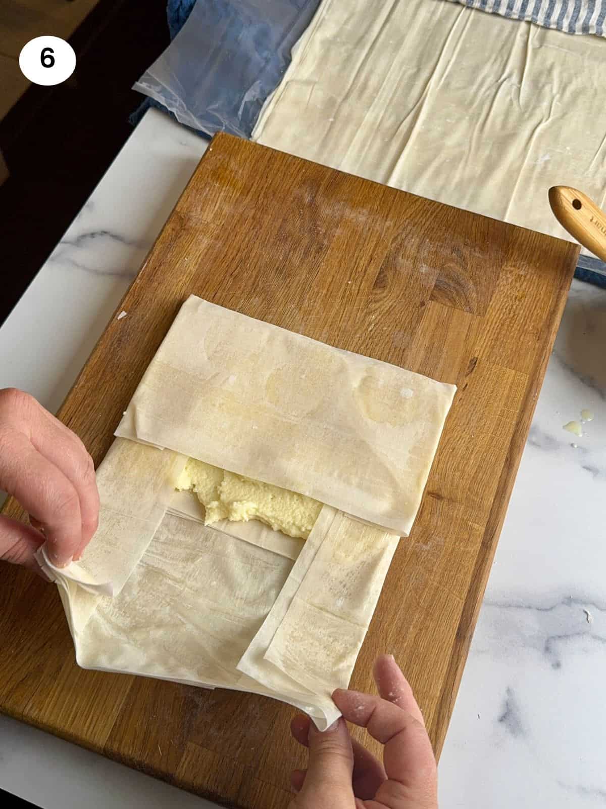 Folding the bougatsa parcel sides.