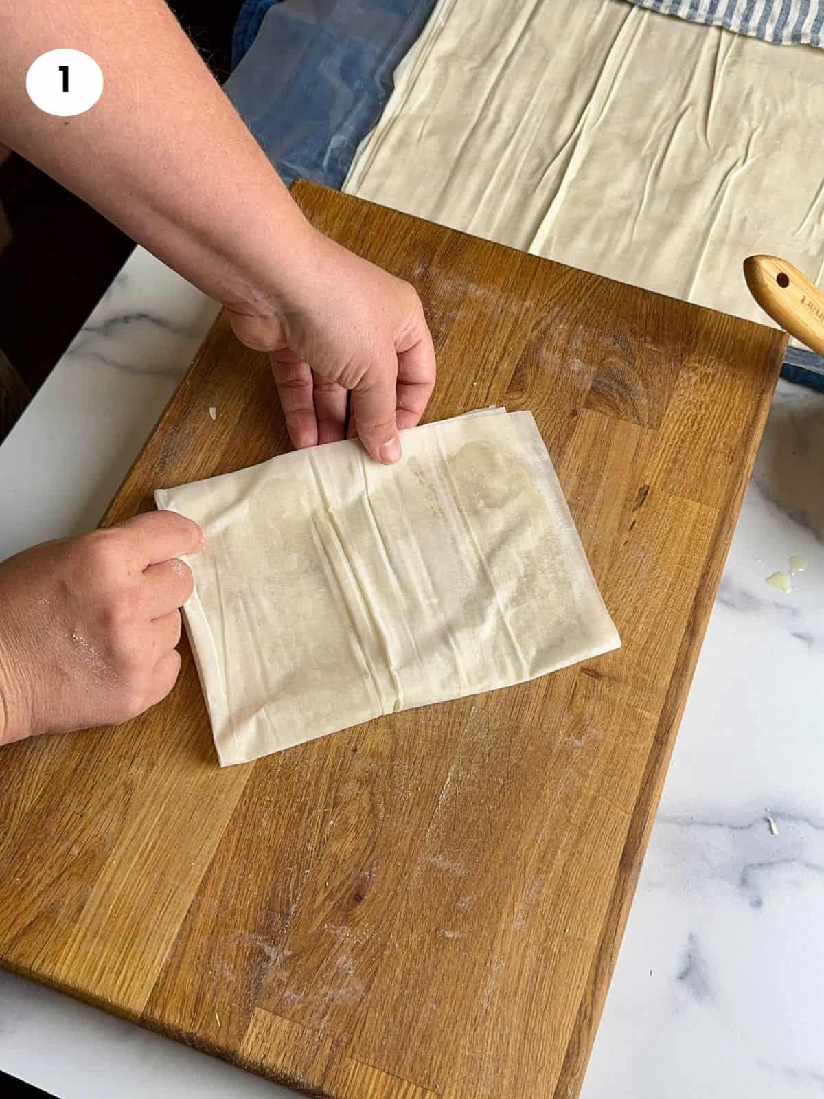 Folding the phyllo sheet into a rectangle.