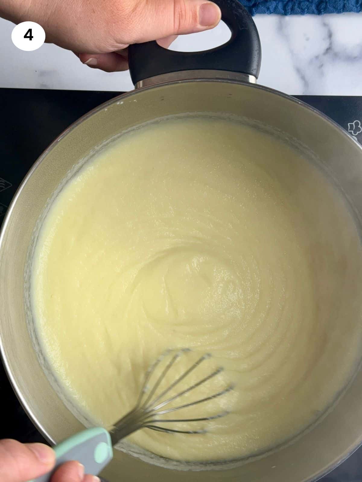 Mixing the cream in the pot until it thickens.