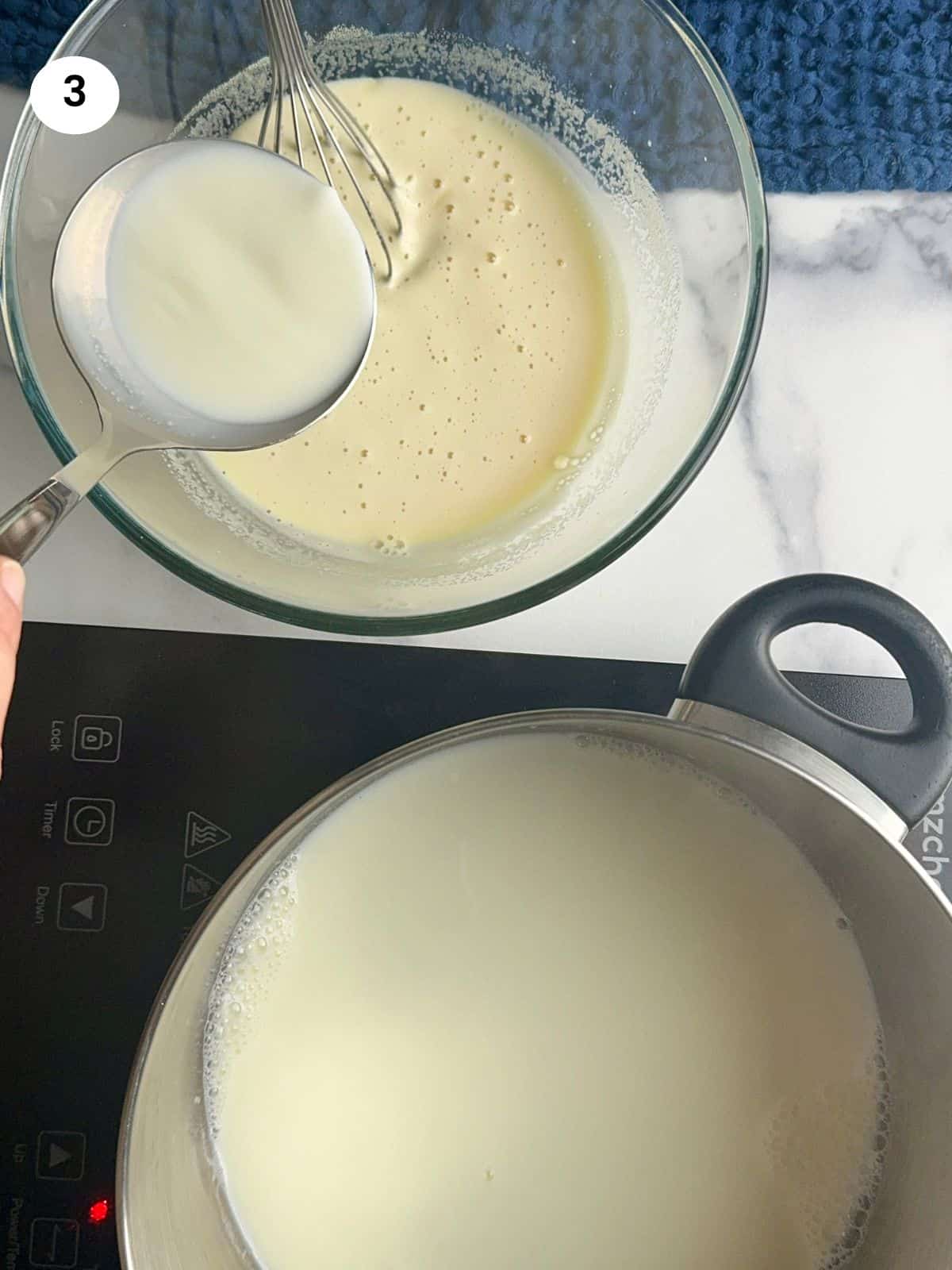 Pouring hot milk into the batter with a ladle.