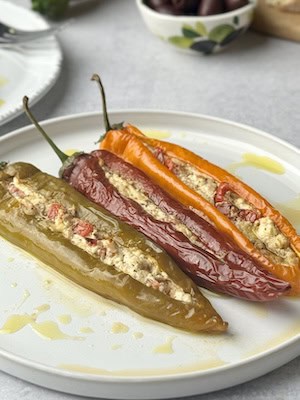 Stuffed peppers with cheeses served in white plate.