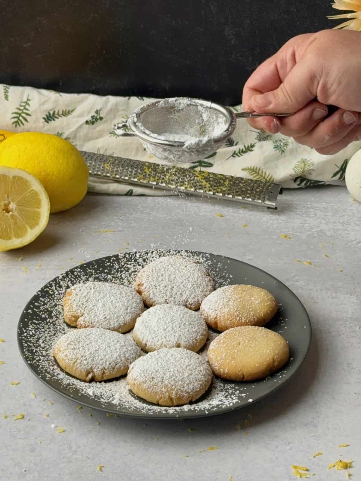 Dusting the lemon cookies with powdered sugar.