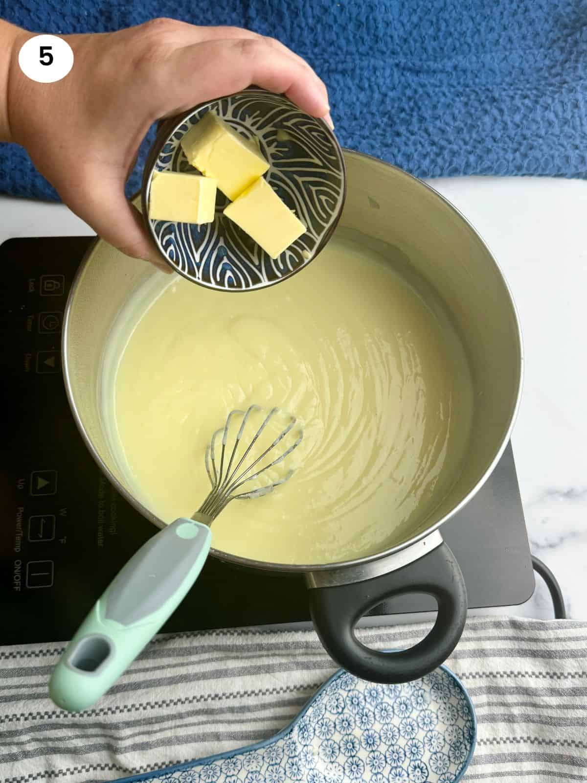 Adding the butter to the pot.