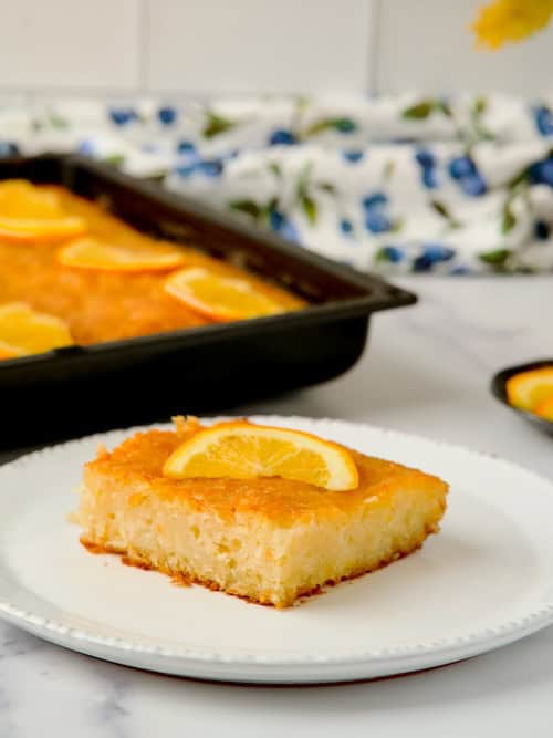 A slice of Greek orange cake served on a white plate.