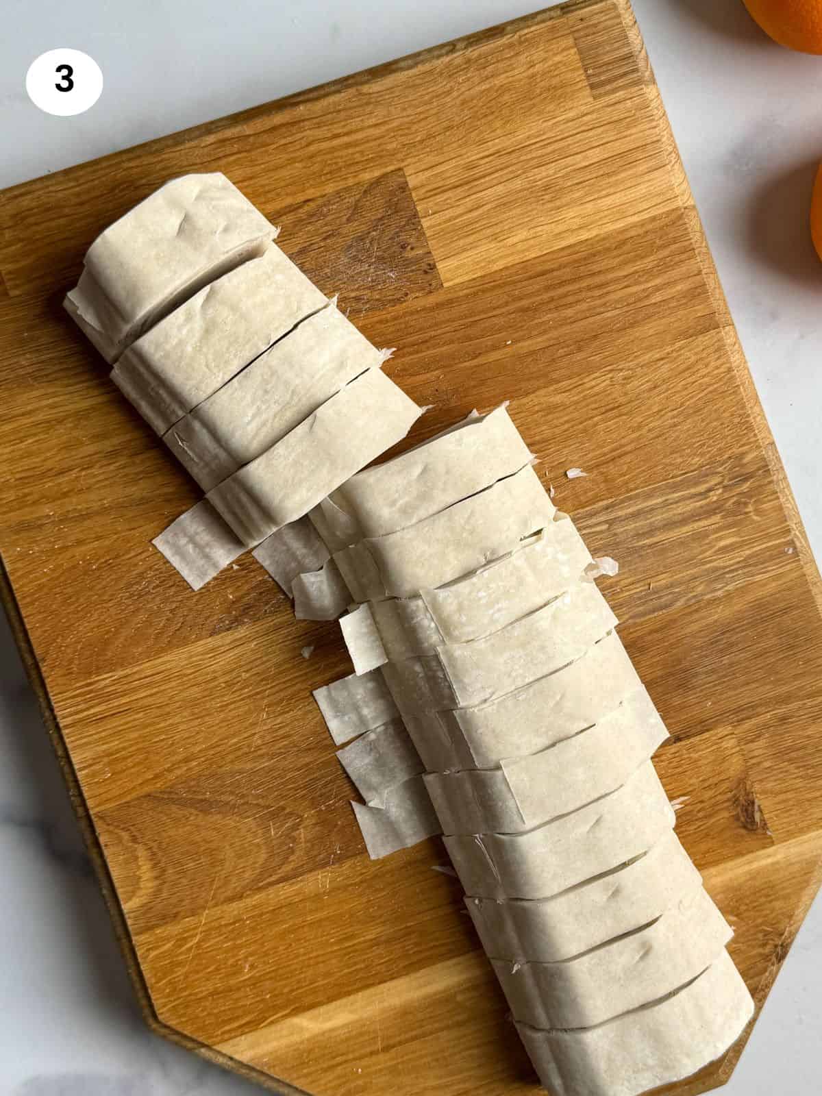 Cutting the phyllo pastry into strips.