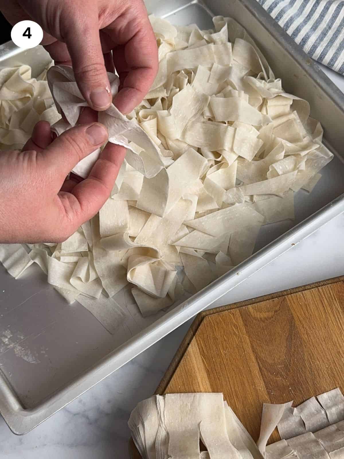 Unrolling the phyllo pastry to dry out.