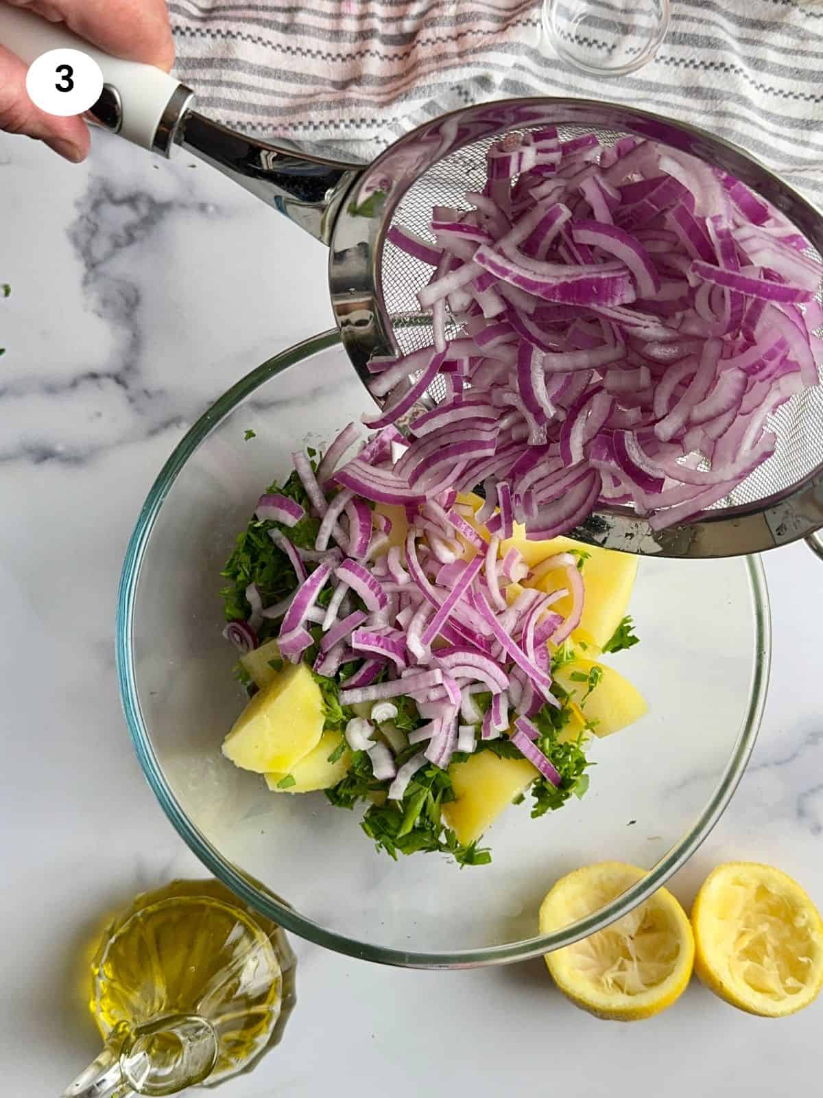 Assembling the potato salad in a bowl.