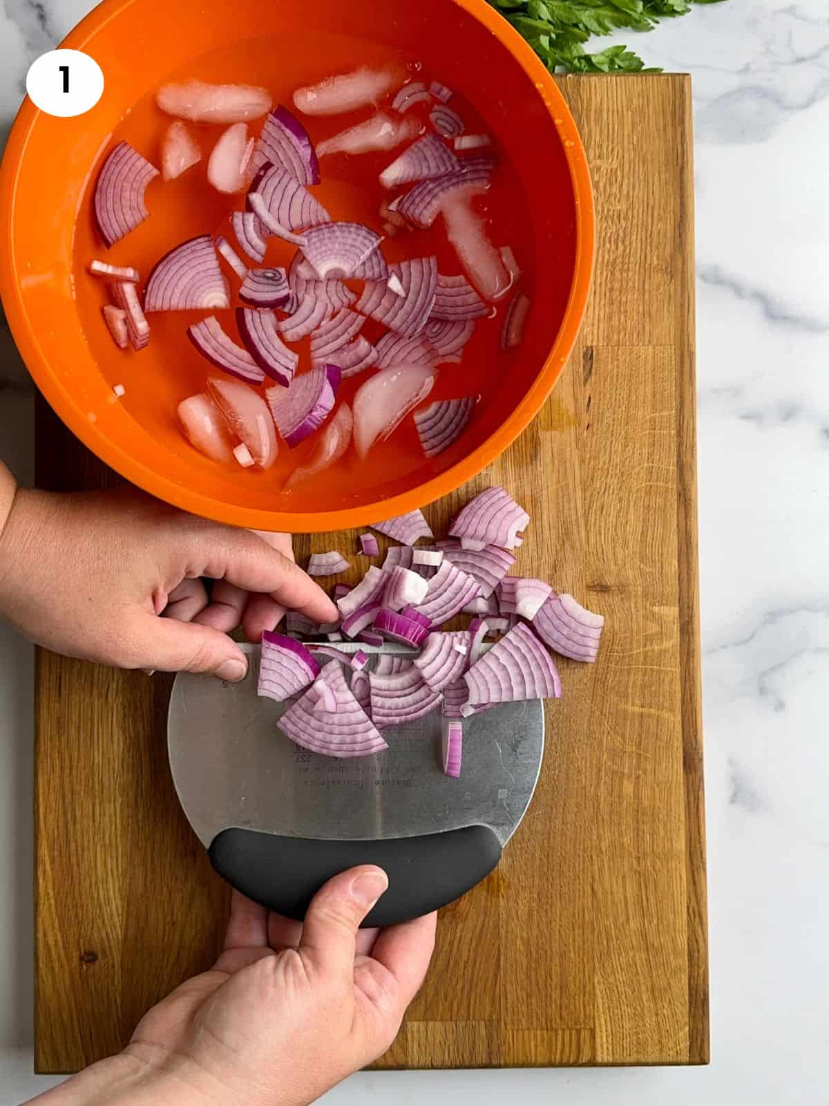 Adding onion slices to a bowl with cold water.