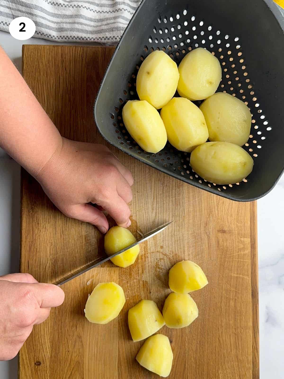 Cutting the boiled potatoes into quarters.