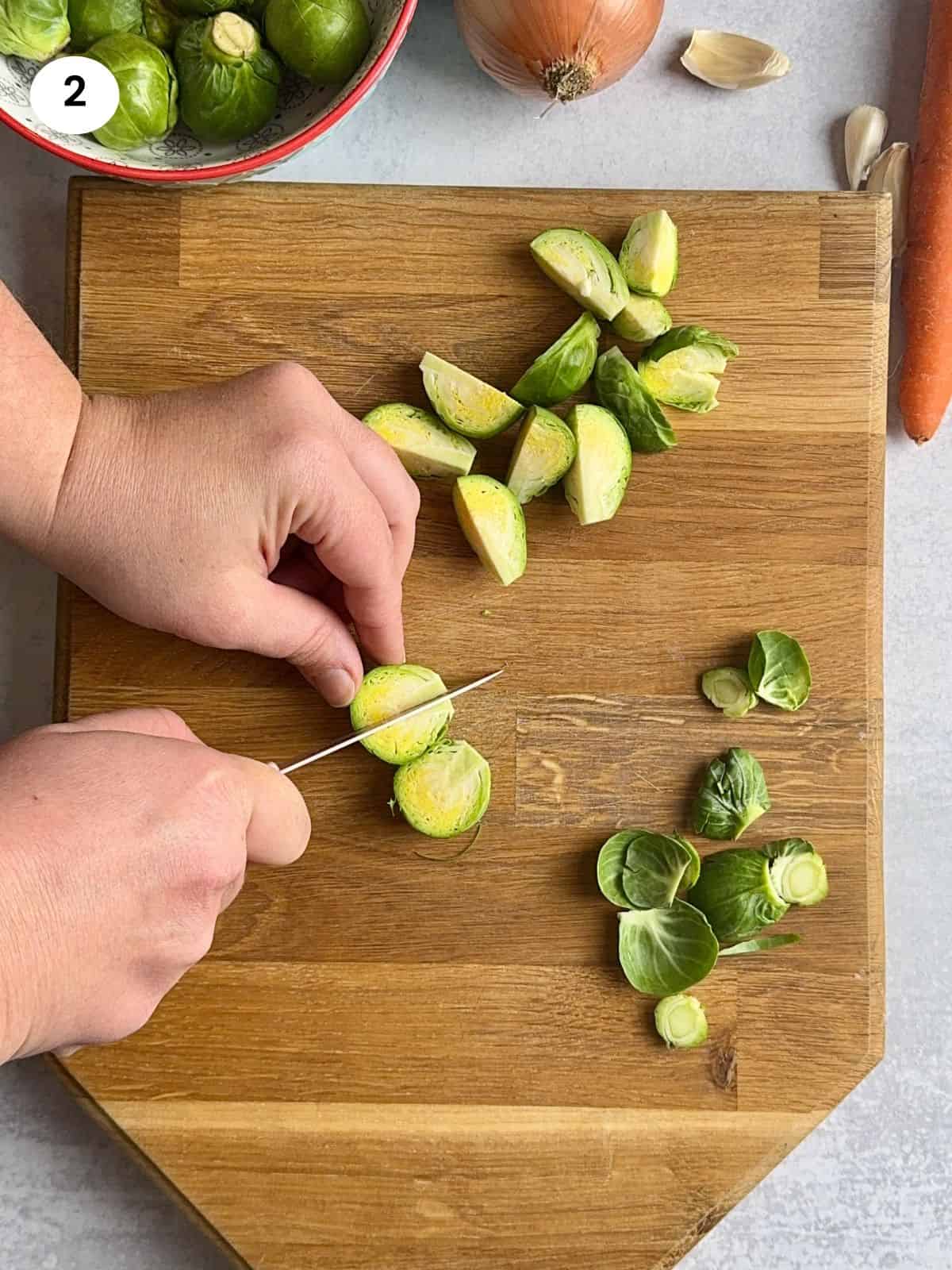 Cutting the brussel sprout into quarters.