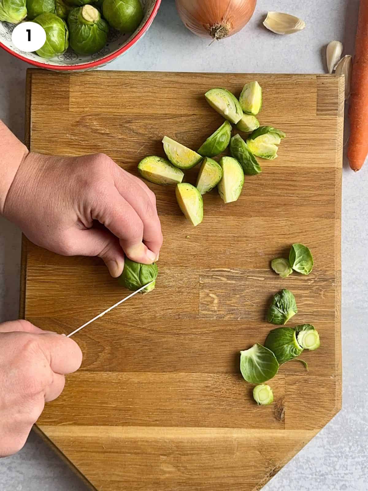 Cutting the bottom of the brussel sprout bud off.