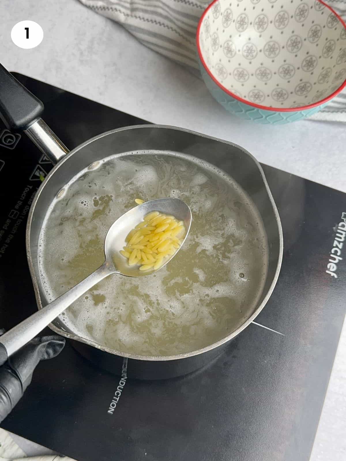 Boiling the orzo pasta.