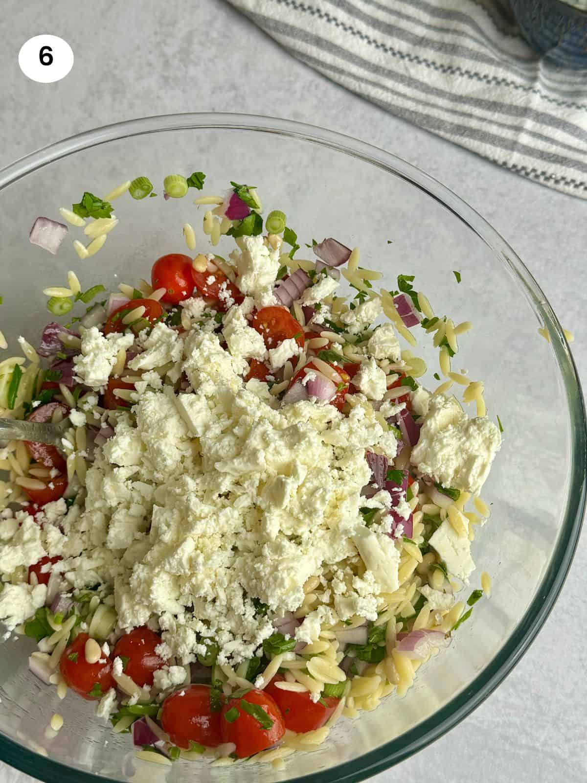 Adding the crumbled feta cheese.