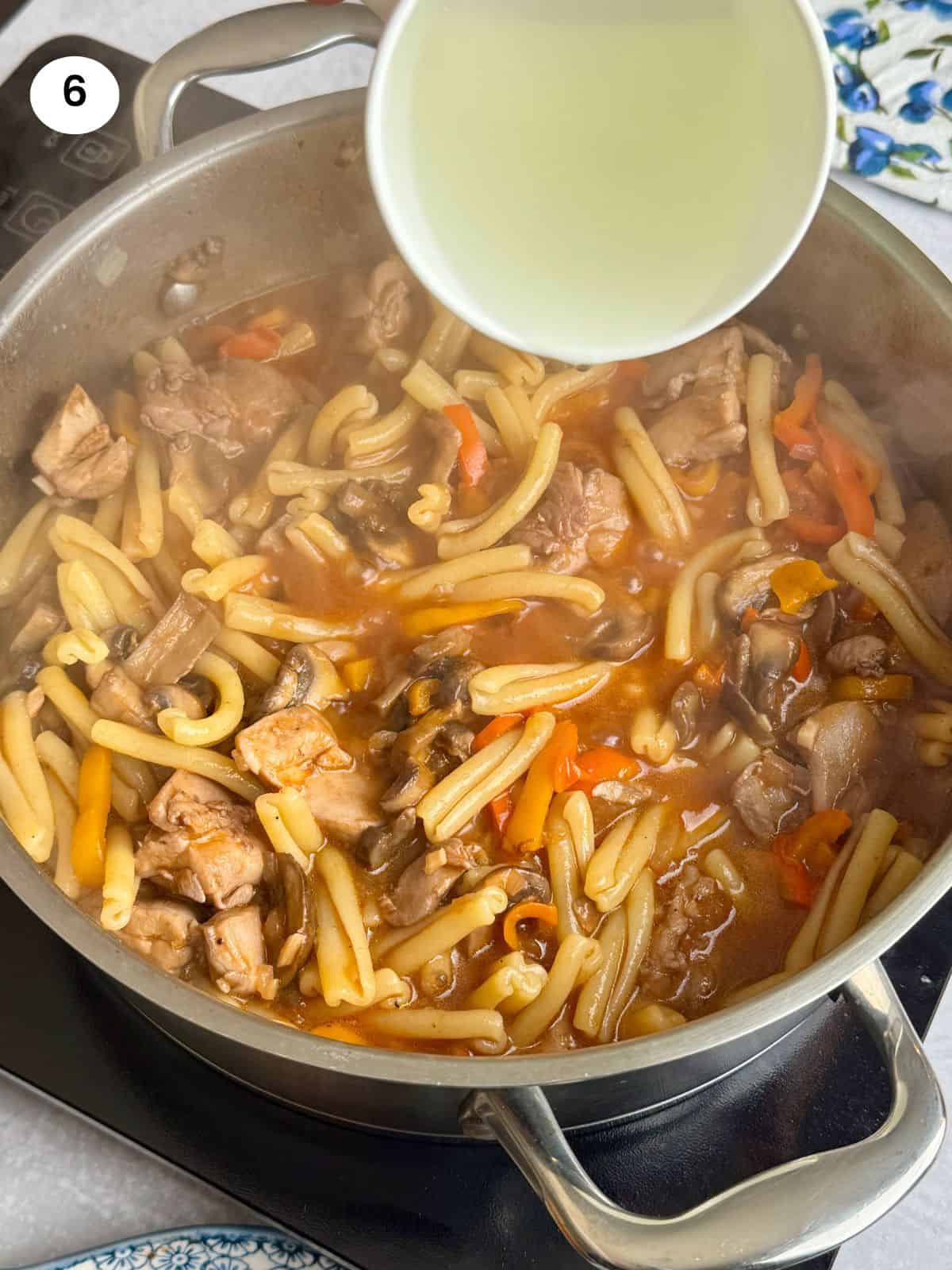 Adding pasta water to the pan.