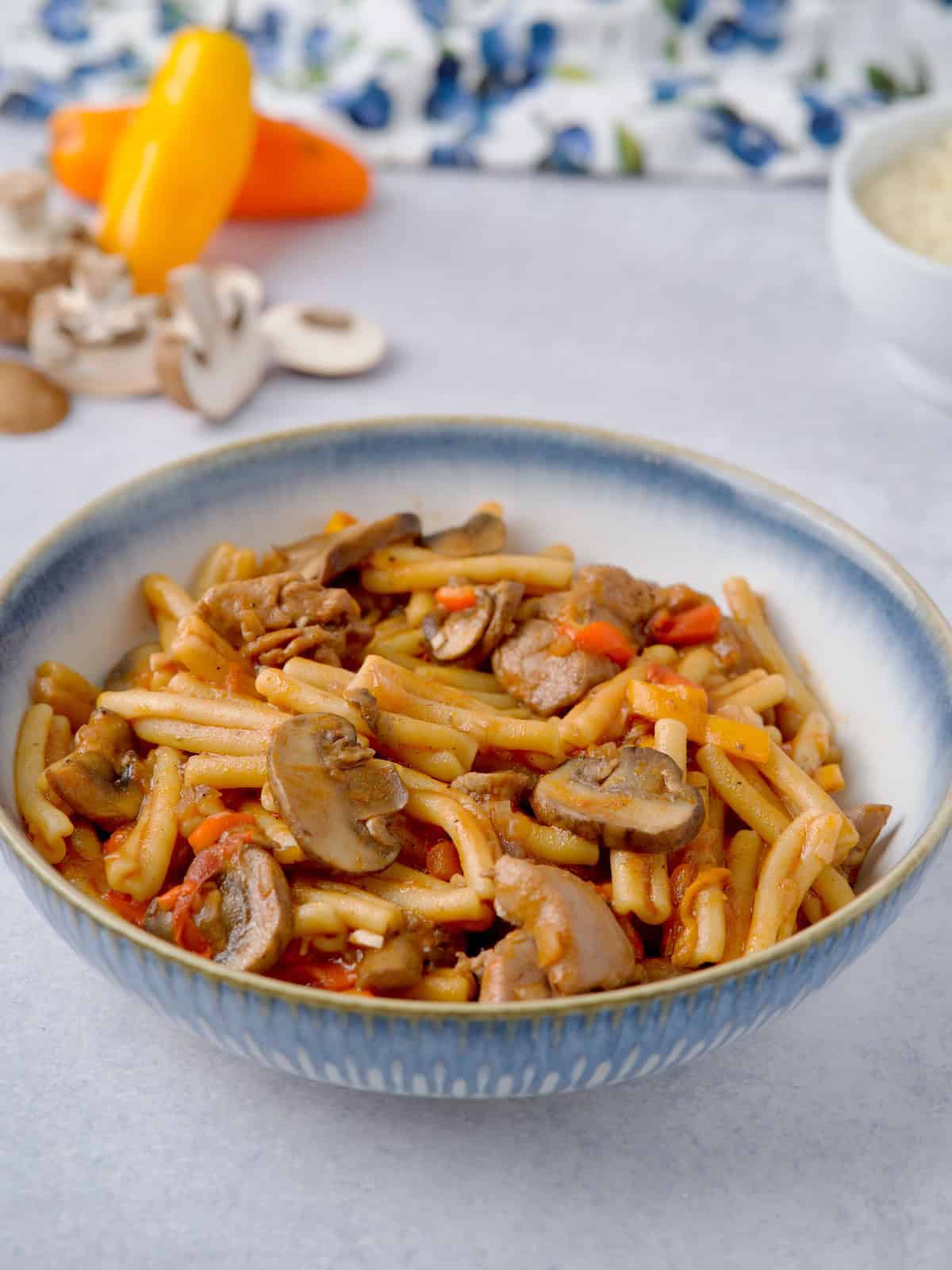 Served chicken and mushroom pasta in a blue bowl.