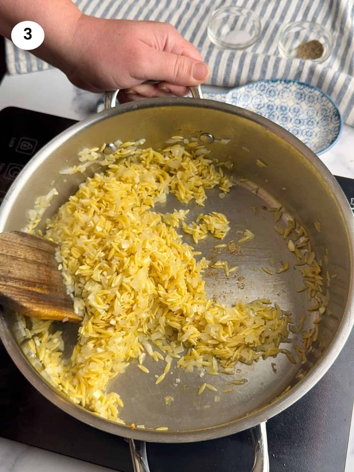 Toasting the orzo pasta with the garlic and onion.