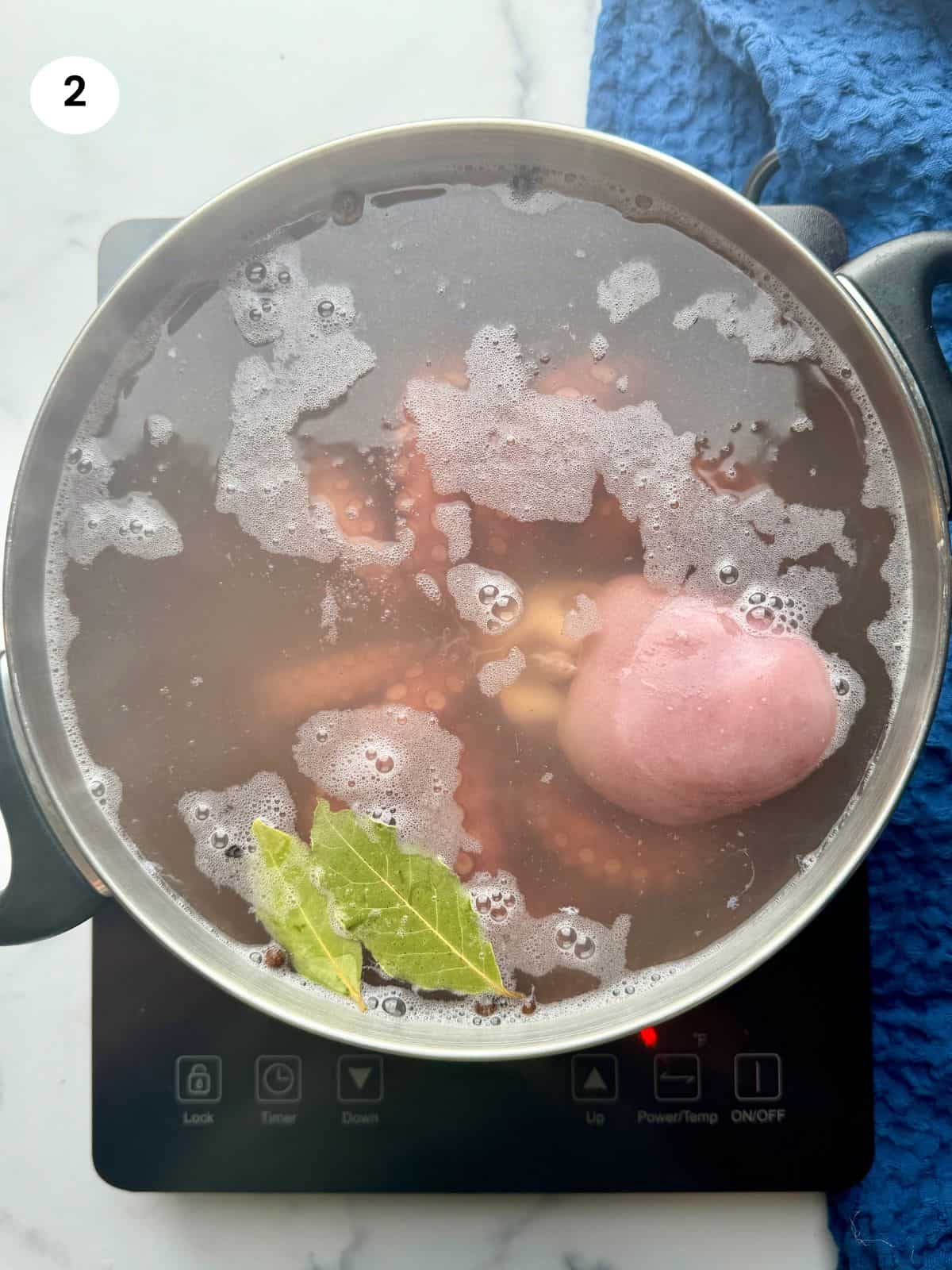 Boiling the octopus until tender.