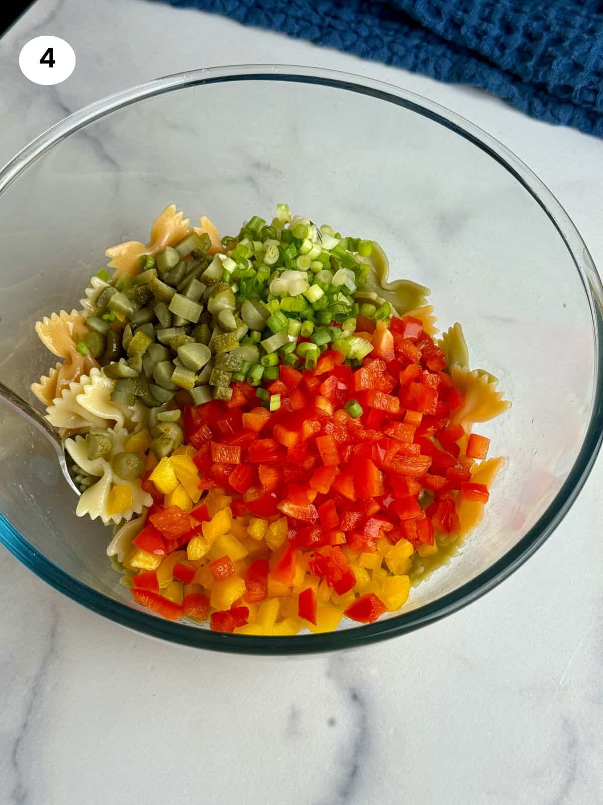 Adding the chopped veggies on top of the pasta.