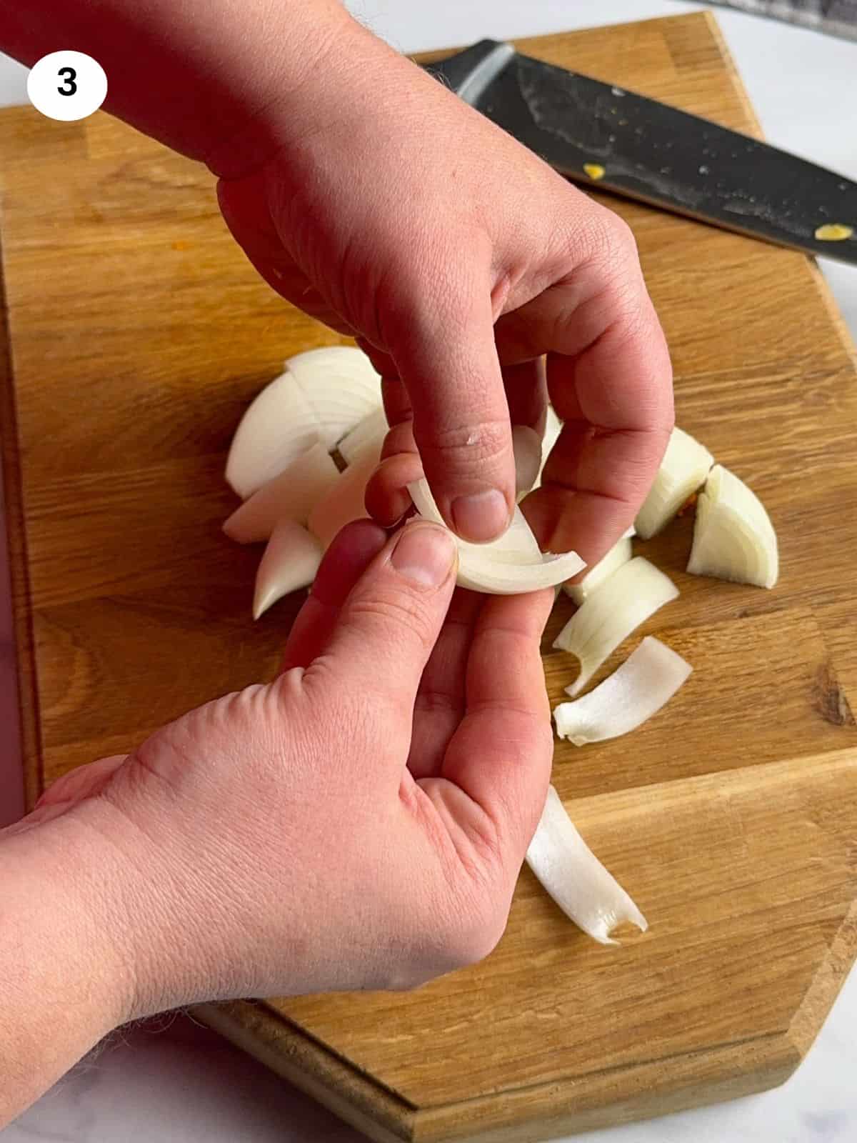 Cutting the onion into chunks.