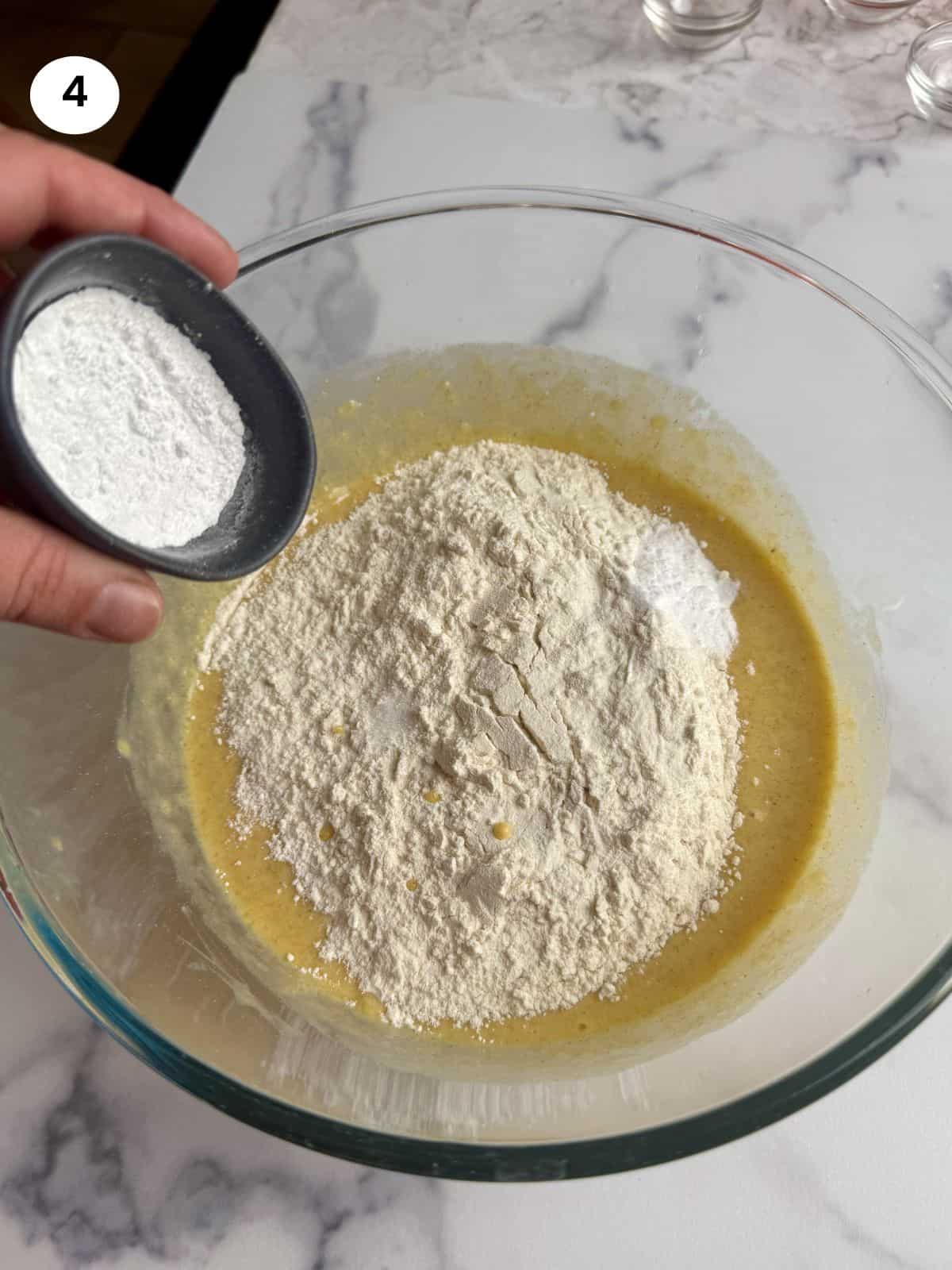 Adding baking powder to the bowl.