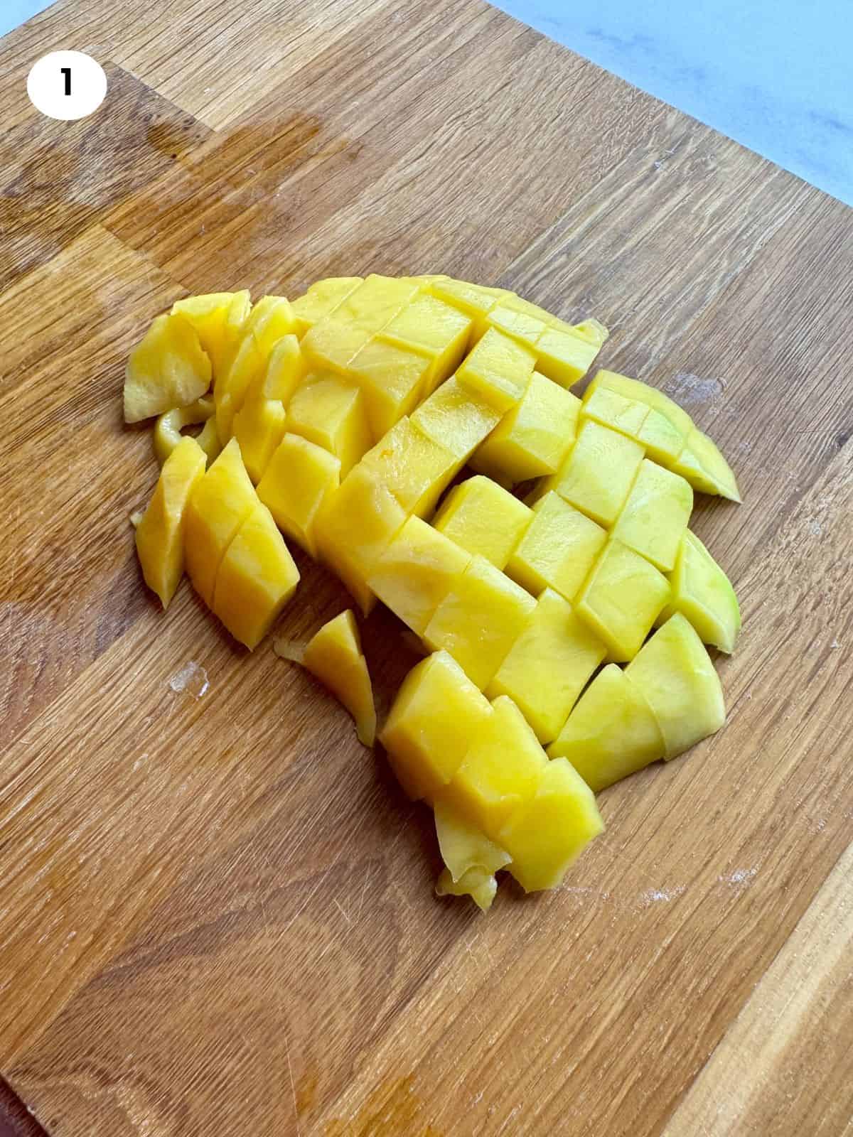 Diced mango on a wooden board.