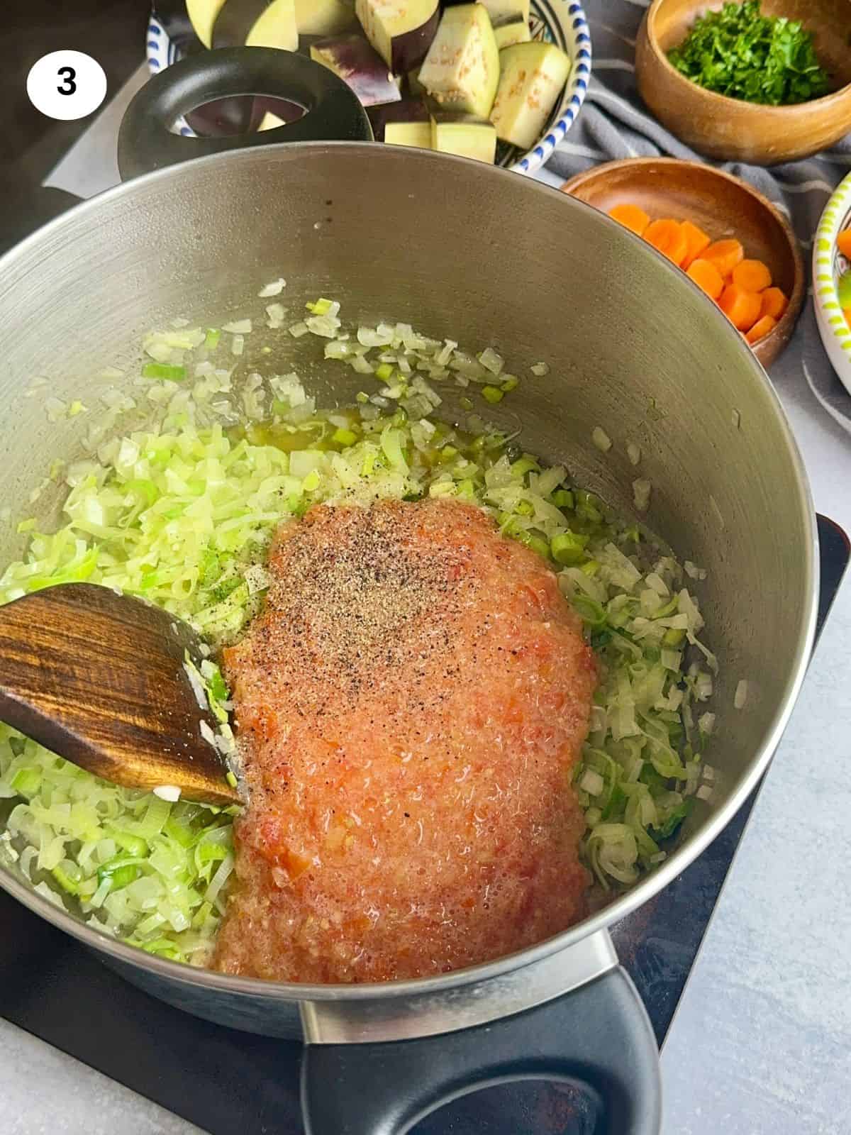 Adding the blended tomatoes and seasoning.