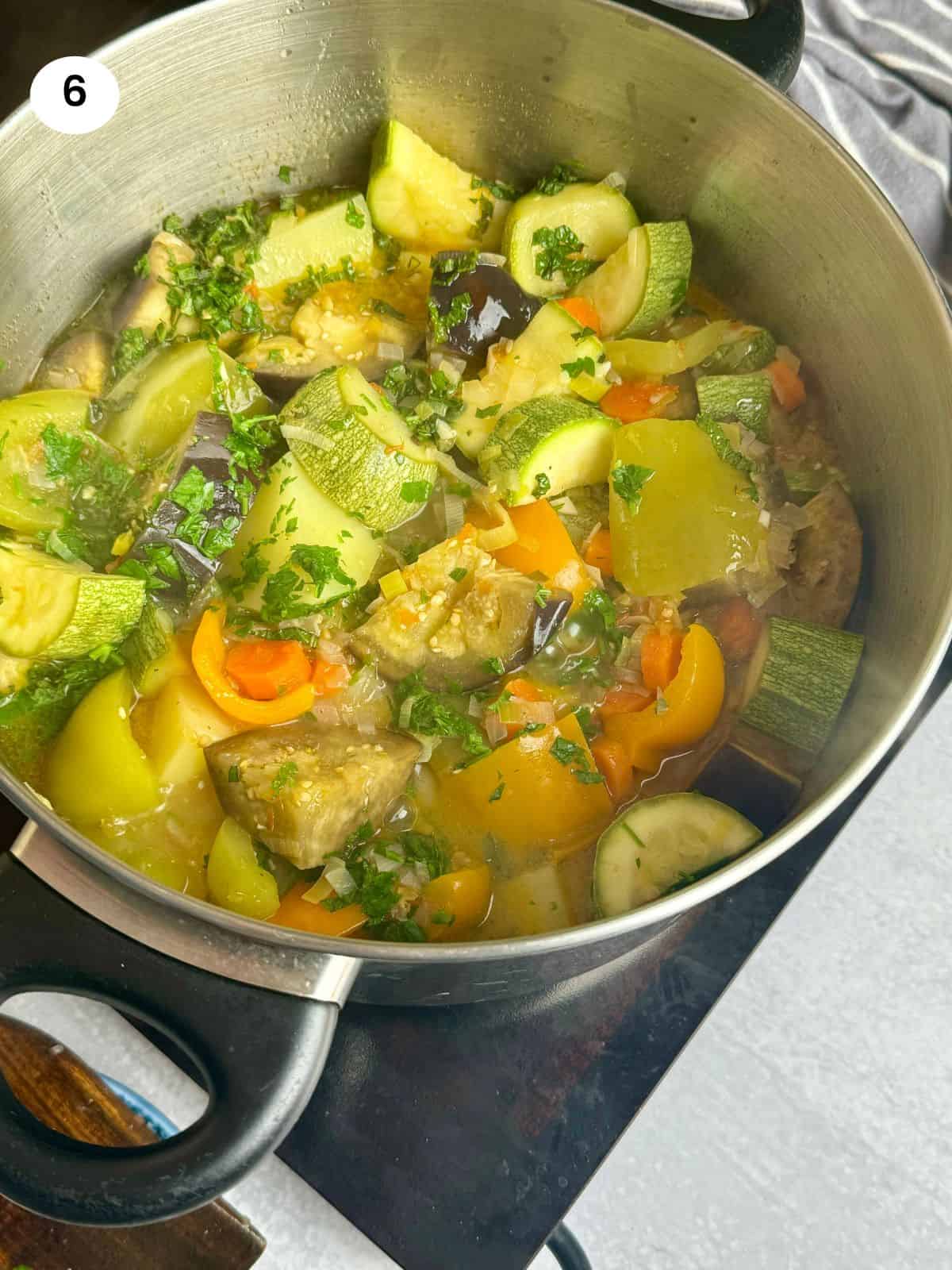 Adding the fresh herbs to the pot towards the end.