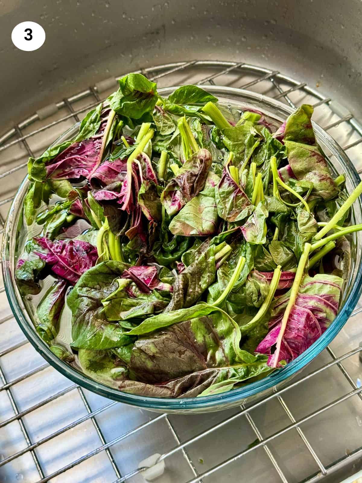 Washing the greens with water and vinegar before cooking.